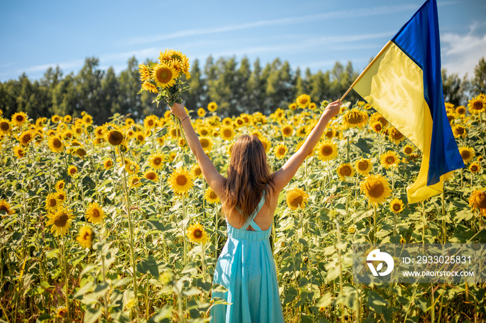 Strong beautiful Woman in Holding Ukraine Flag amongst Sunflowers, Standing for Peace