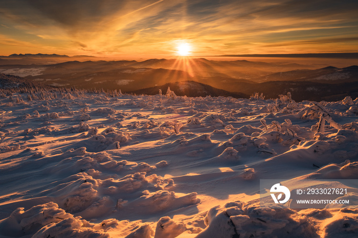 Winter sunset seen from Pilsko in Beskid Żywiecki. Beautiful views of the Tatras and the Mala Fatra massif, bathed in golden light.