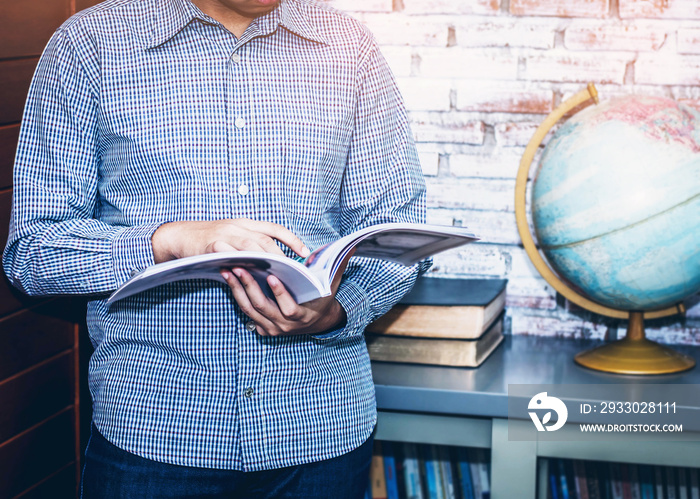 image of young  business man  reading magazine  at office with burred of world globe background