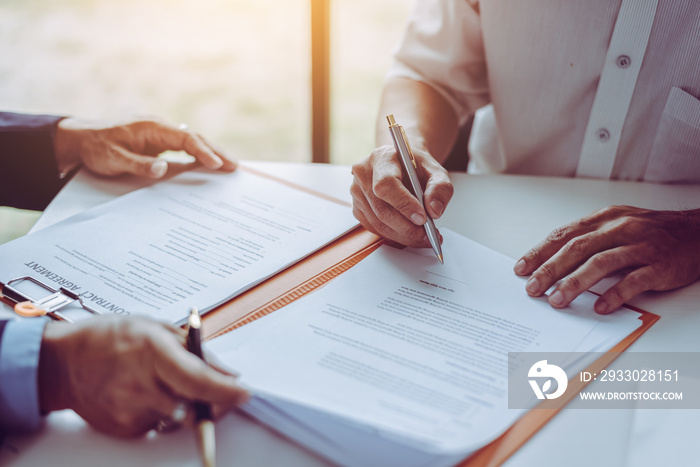 Group of middle age Asian business people and lawyers discussing and sign a contract.