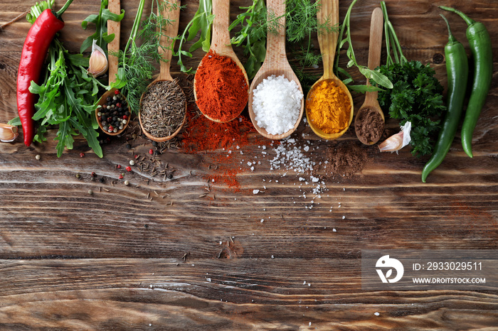 Various fresh herbs with dry spices on wooden table