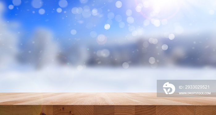 A wood table, tabletop product display with a festive Christmas outdoor background of blue sky, snow and sunshine bokeh.