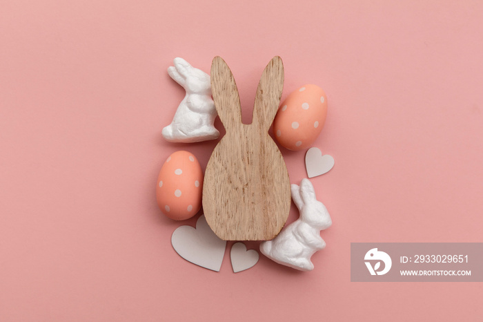 Minimal easter holiday background. Wooden easter bunny and egg on pink