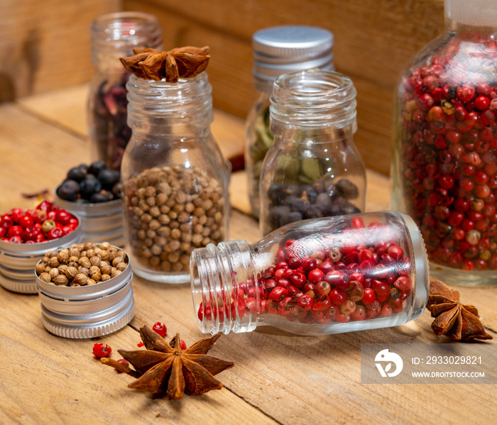 Professional set of gin spices in small bottles, pink pepper, hibiscus flowers, juniper berries, cardamom, coriander seeds, star anise