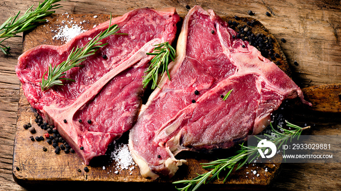 Raw fresh meat t-bone steak and seasoning on wooden background