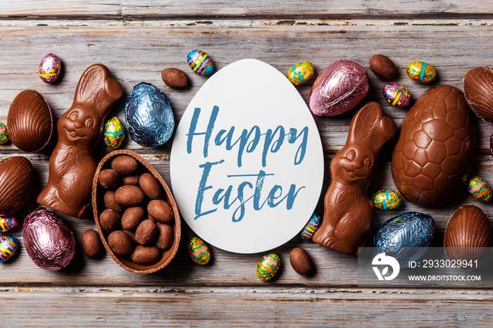 Chocolate easter eggs and bunnies on a rustic wooden background