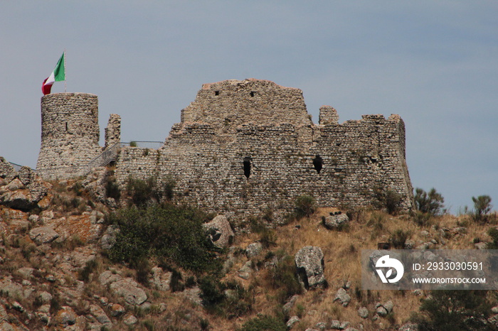 On the top of The Fortress of Tolfa .Decorated with an Italian flag on top ,there are the remains of the Castle of the Fortress.Photography on  Remote view.Tolfa (RM) ,ITALY