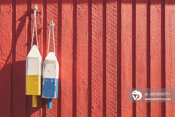 Fishing buoys on red wooden wall, horizontal