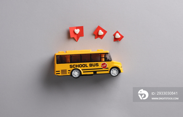 Toy school bus with Social media likes on gray background. Creative minimal layout