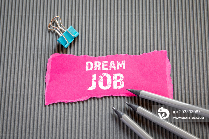 DREAM JOB. Career, education and job interview concept. Text on torn, colored paper