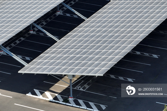 Aerial view of solar panels installed over parking lot with parked cars for effective generation of clean energy