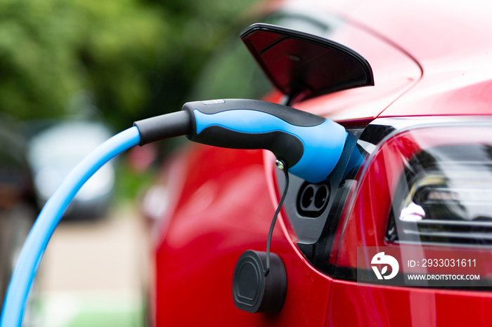 Electric car charging at plug in charge station in a public car park in Suffolk, UK