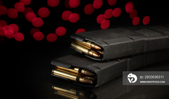 Loaded AR-15 magazines with Christmas lights behind