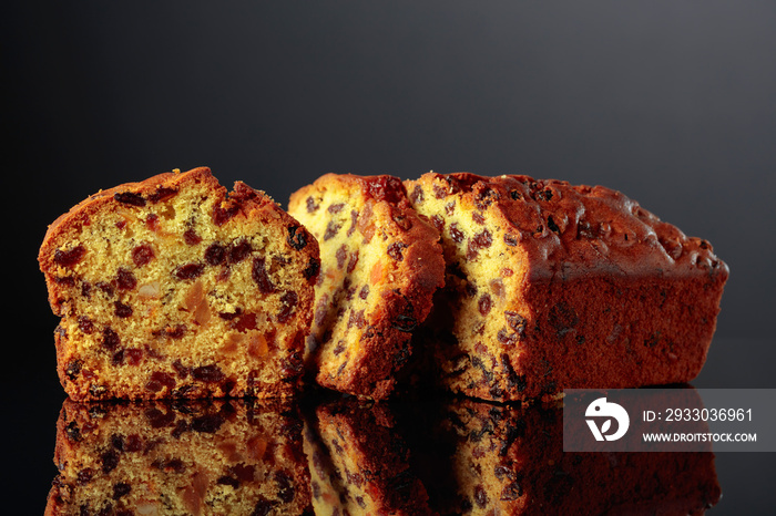 Cake with raisins and candied fruit on a black background.