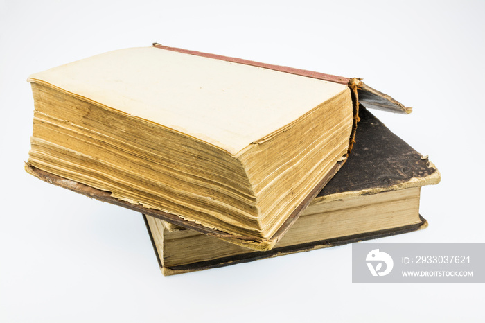 Two old books, one in an open kind, on a white background.