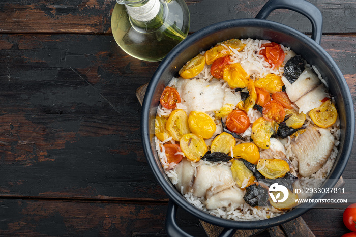 One pan fabulous fish with basmati rice and cherry tomatoes, on old wooden table, top view with copy space for text