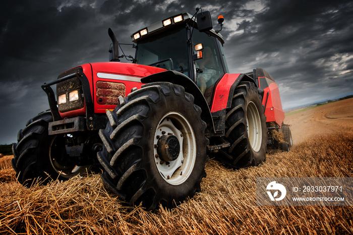 farmer in fields making straw bales