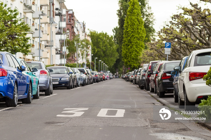 Rows of cars parked on the roadside in residential district