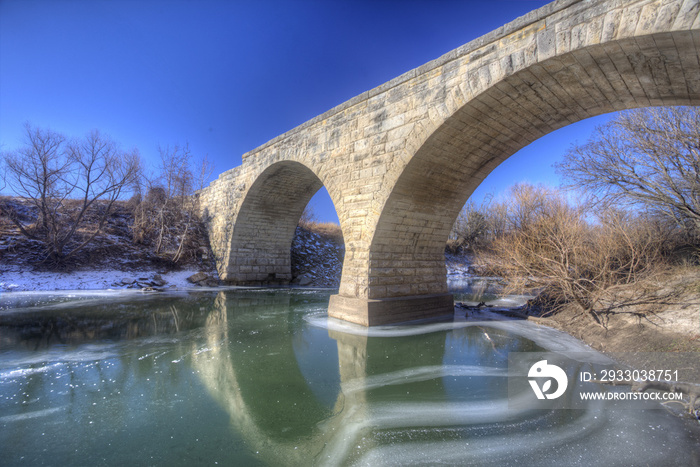 Clements Stone Arch Bridge over frozen stream, rural Kansas