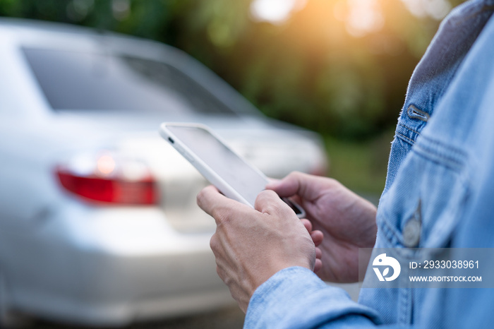 emergency safety. man is dialing a cell phone for an emergency number due to a car breakdown in the forest. Maintenance of the car before the trip increases safety from accidents.