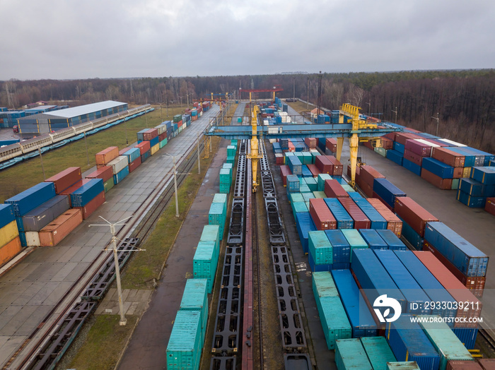 Multicolored freight containers at the railway customs. Aerial drone view.