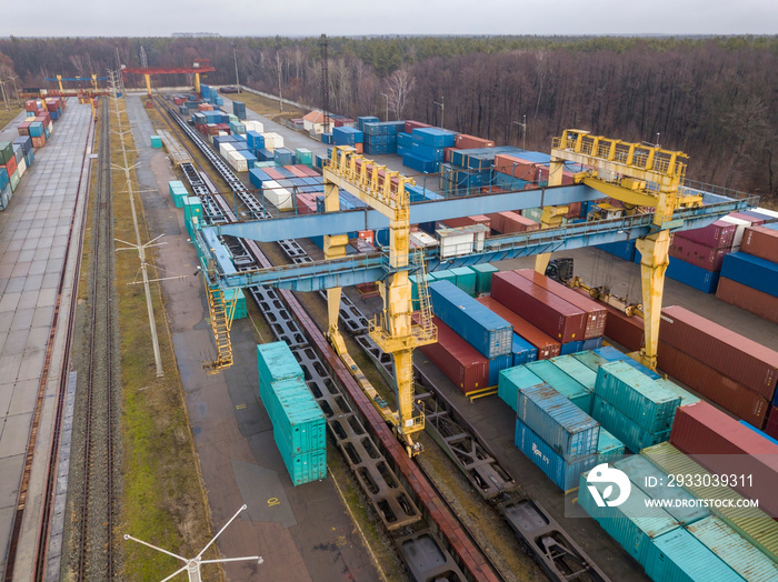 Multicolored freight containers at the railway customs. Aerial drone view.