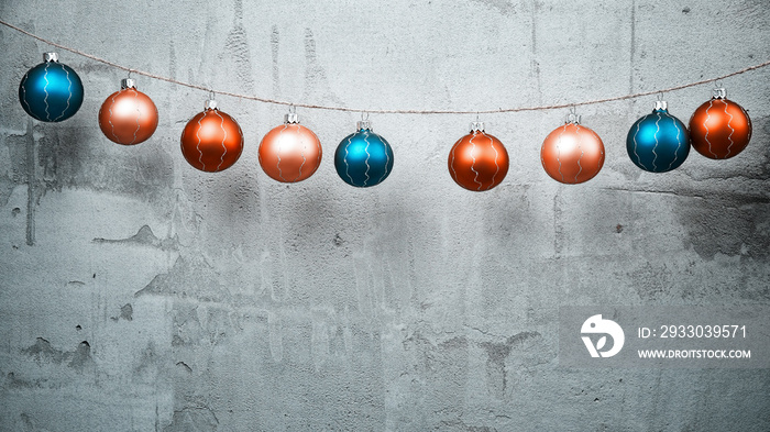 Colored Christmas balls hanging on concrete wall background