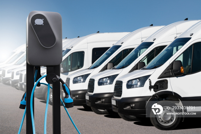 Electric vehicles charging station on a background of a row of vans. Green transportation concept