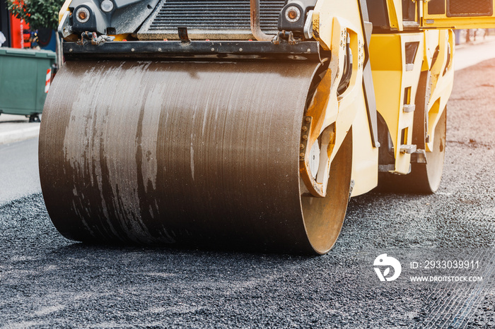 The roller paver levels the asphalt during the construction of the highway road