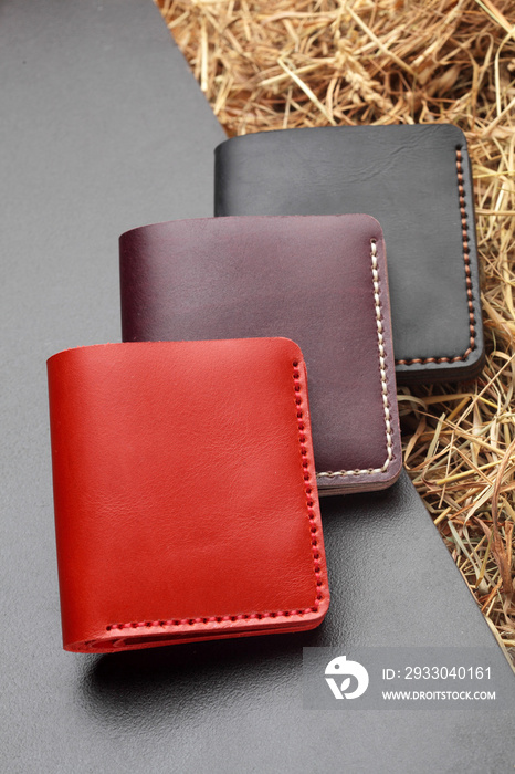 Set of three red brown and black wallet. Hand made leather man wallet . Multi colored. Leather craft.On cretive background .Top view