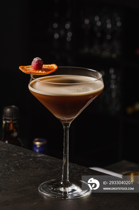 Espresso Martini Cocktail based on coffee, liqueur and vodka. Served with orange chips and raspberry. Space for text