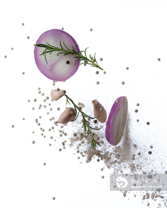 Red onion, garlic,rosemary and pepper splash or explosion flying in the air isolated on white background