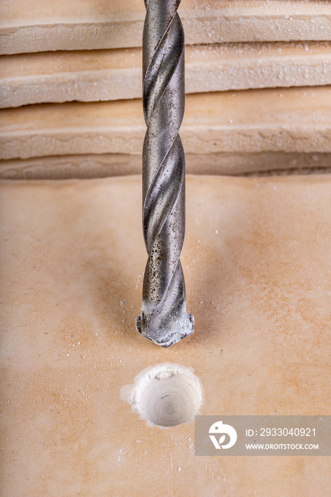 Drilling with a carbide drill bit in a ceramic plate. Small work in the workshop.