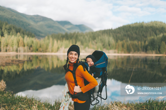 A mother hiking in the Canadian mountains with her baby on her back.