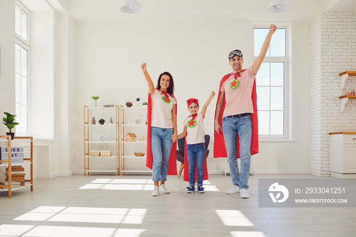 Happy family in superhero costumes plays adventure at home.