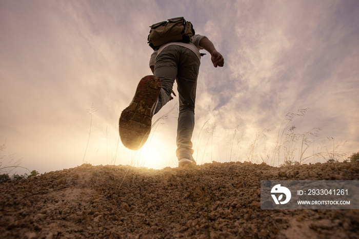 Motion blur man hiker adventure to overcome limit of life on the trail at sunset mountains with  backpack.