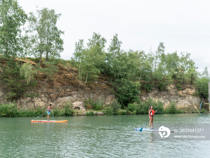 Friends paddleboarding on lake