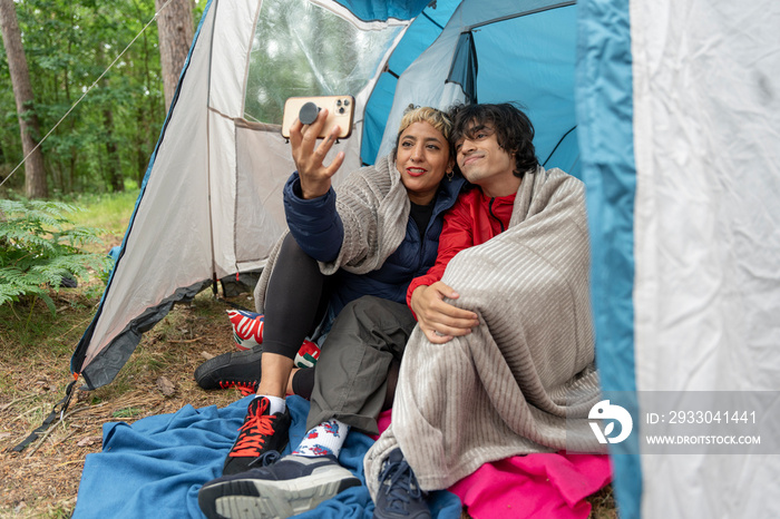 Mother and son taking selfie in tent