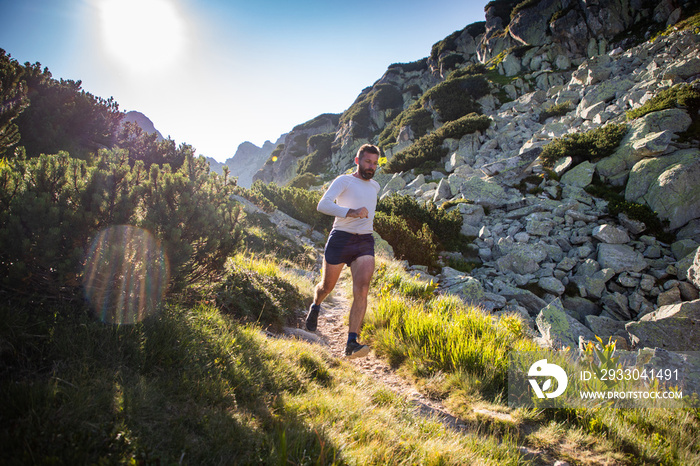 trail runner running in mountain landscape at sunset active lifestyle