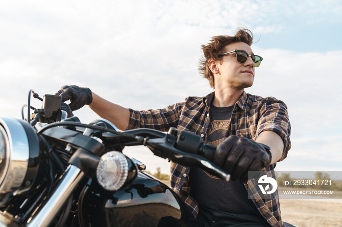 Man biker on bike outdoors at the desert field.