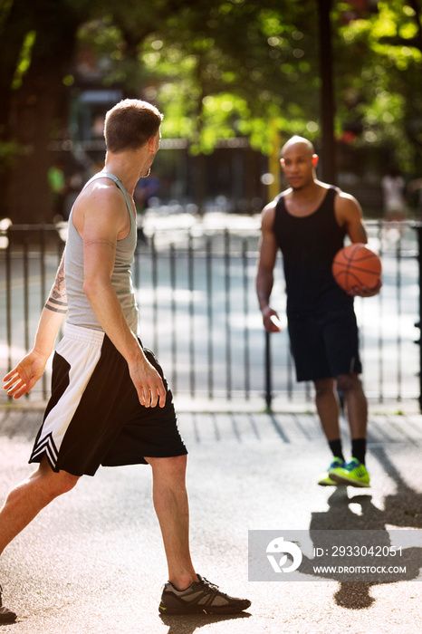 Men playing basketball on court