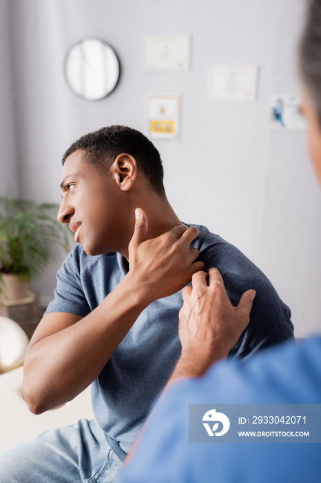 blurred doctor touching injured african american patient