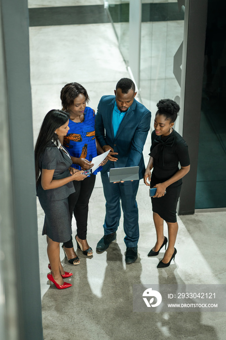 Diverse businesspeople working on a tablet together in an office lobby