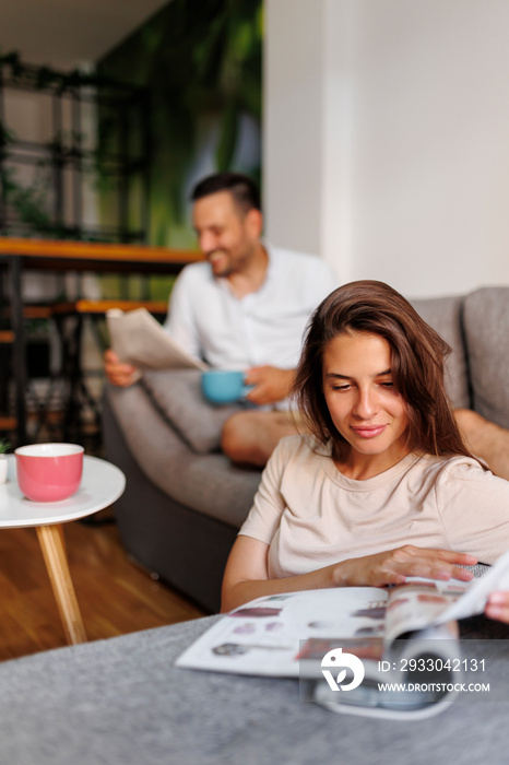 Couple reading newspaper and drinking coffee