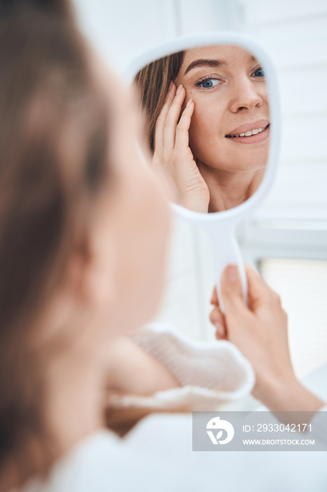 Focused photo on female hand holding mirror