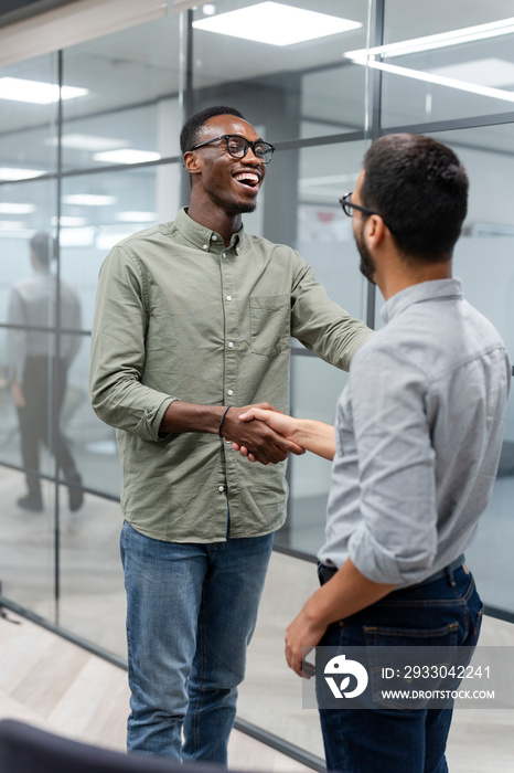 Two men shaking hands in office