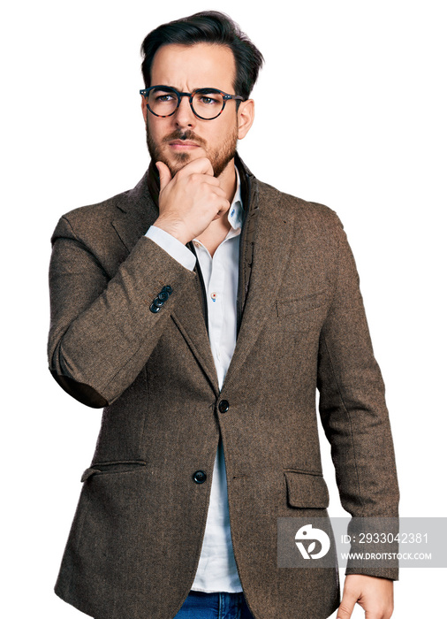Young hispanic man wearing business jacket and glasses with hand on chin thinking about question, pensive expression. smiling with thoughtful face. doubt concept.