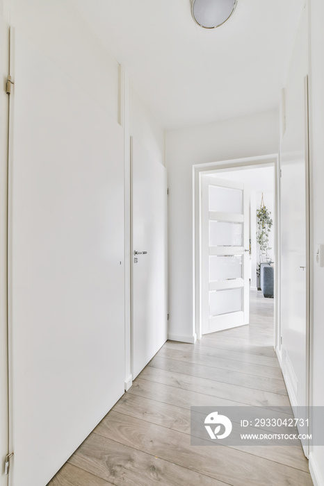 Delightful long light corridor with an open door at the end