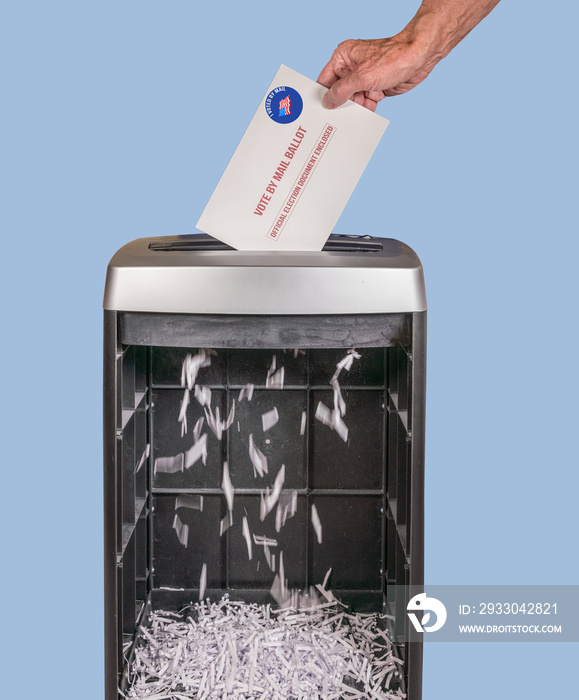 Vote by mail or absentee ballot being shredded in office paper shredder as illustration of voting fraud or lost votes in Presidential election