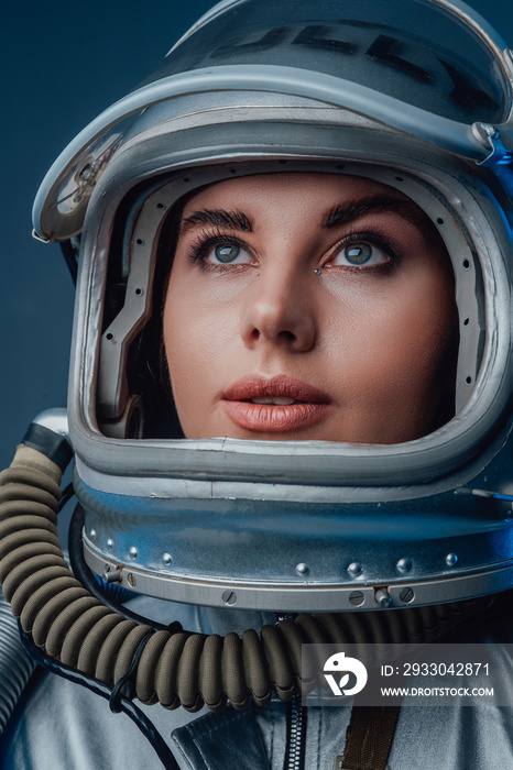 Female modern cosmonaut in spacesuit and helmet